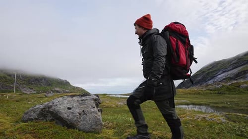 Young Happy Man Hiking on the Top of a Mountain with a Backpack Autumn Norway Lofoten