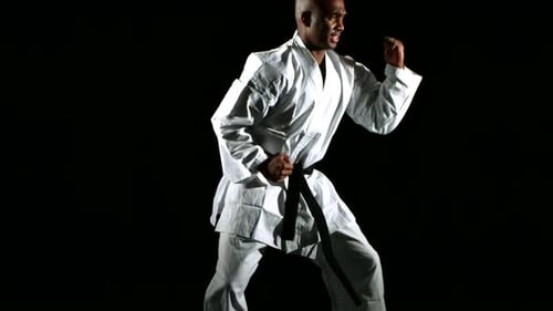 Karate Man Demonstrates Punches in Dark Studio