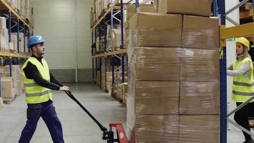 Warehouse Workers Pulling a Pallet Truck