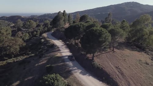 Foto aérea revela foto de carro dirigindo em uma estrada na encosta com vista panorâmica na Espanha
