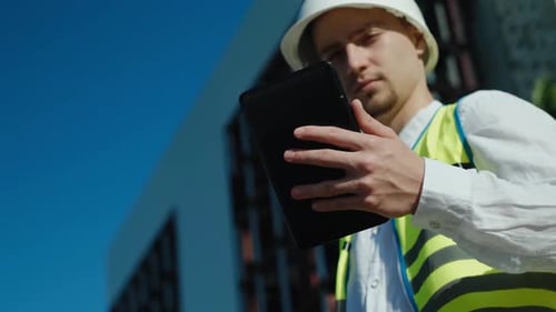 Engineer Working With Tablet Outside Urban Building
