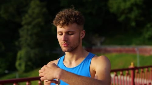 Close Up of Handsome Sportsman Drinking Water From Bottle Standing Outdoor and Looking Away After