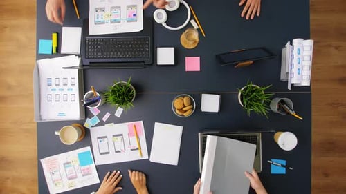 Business, People and Team Work Concept - Team of Startuppers with Gadgets