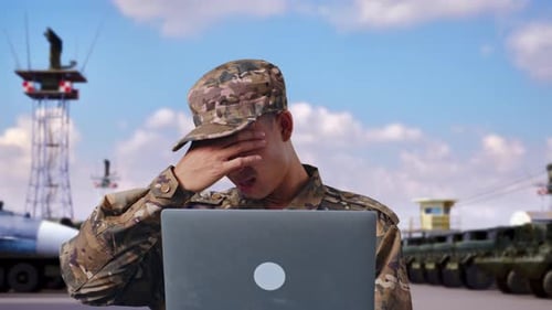 Close Up Of Asian Man Soldier Using A Laptop And Having A Headache At Military Camp