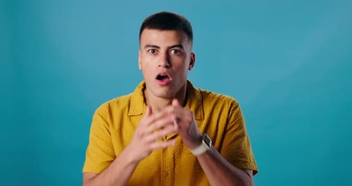 Face, surprise and man with announcement, wow and emoji reaction on blue studio background