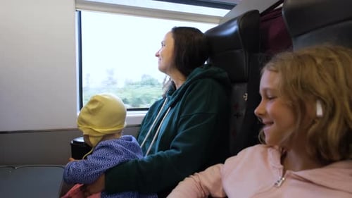Madre con dos hijos disfrutando de un viaje en tren