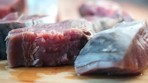 Freshly Cut Fish Fillets Arranged Neatly on a Wooden Cutting Board Ready for Preparation