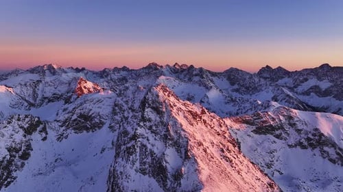 Breathtaking aerial view of the majestic Alps at sunset over snow-covered peaks