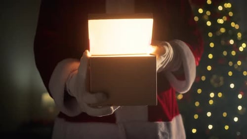 Person Dressed as Santa Opens a Lit Christmas Gift
