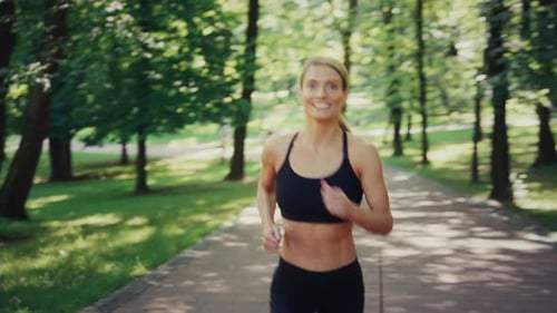 Fit Woman Jogging in Park on Sunny Morning