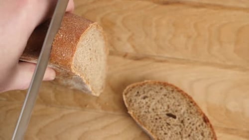 Bread Slices Being Cut With a Knife