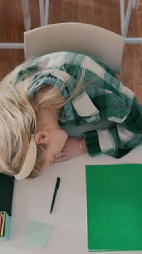 Above, teenager and sleeping in high school with desk, difficult exam and burnout from learning