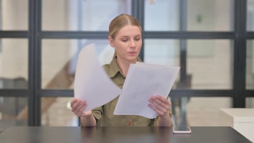 Mature Adult Woman Reading Documents at Work