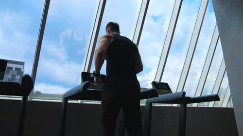 Man running on the treadmill. Athletic man running on treadmill in fitness gym