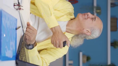 Vertical video of Home office worker sprays perfume on old man.