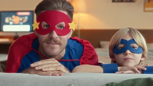 Father and Son Dressed as Superheroes Indoors