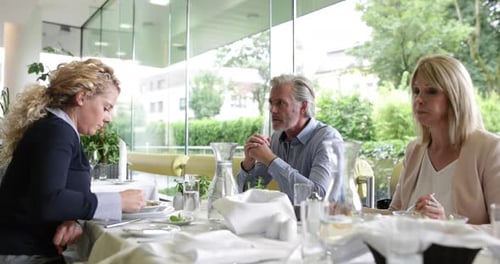 Coworkers Discuss Business at a Table in Restaurant