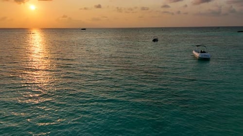 Tranquil Ocean with Boats at Golden Sunset