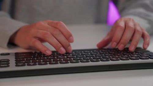 Girl types on keyboard in cozy workspace setting