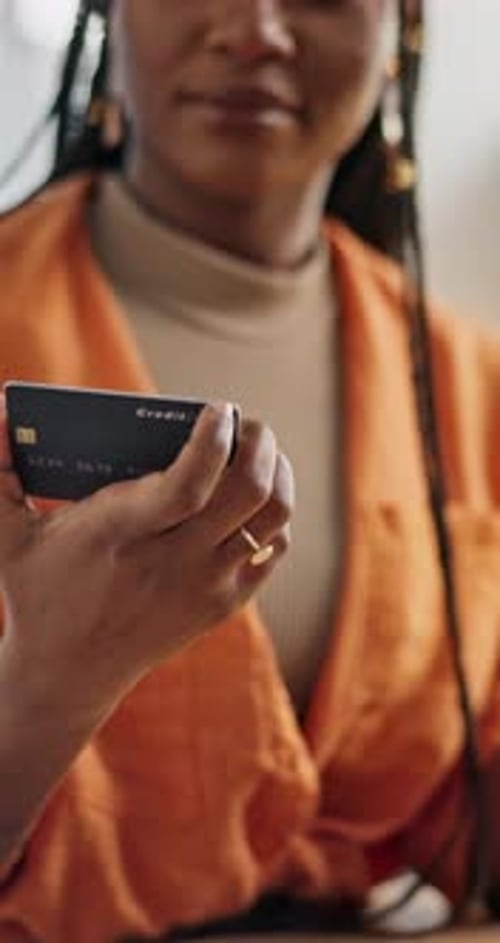 Woman Holds Credit Card and Phone Smiling