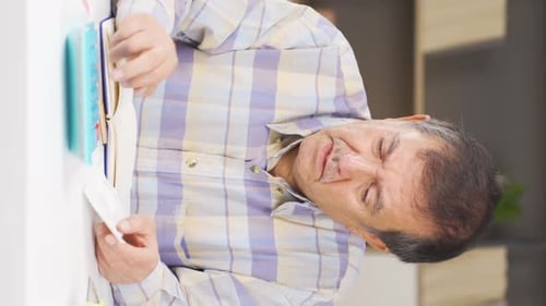 Adult Man Calculating Finances at a Table Indoors