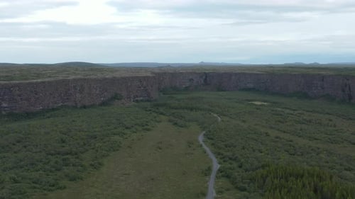 View of Asbyrgi canyon with woodland in Iceland on cloudy day, aerial