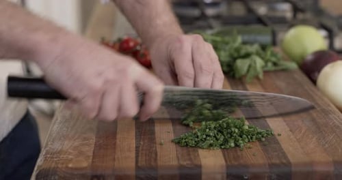 Close Up of Herbs Being Chopped on Cutting Board