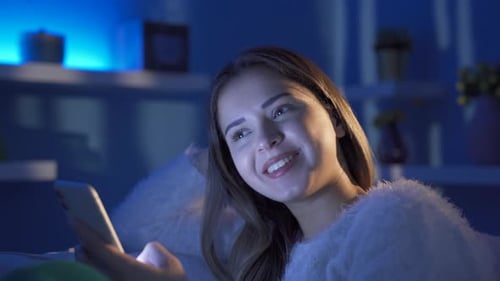 Woman Using Smartphone Indoors at Night
