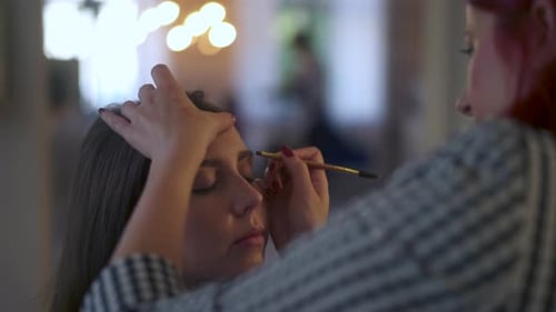 Makeup Artist Carefully Applying Makeup with Brush