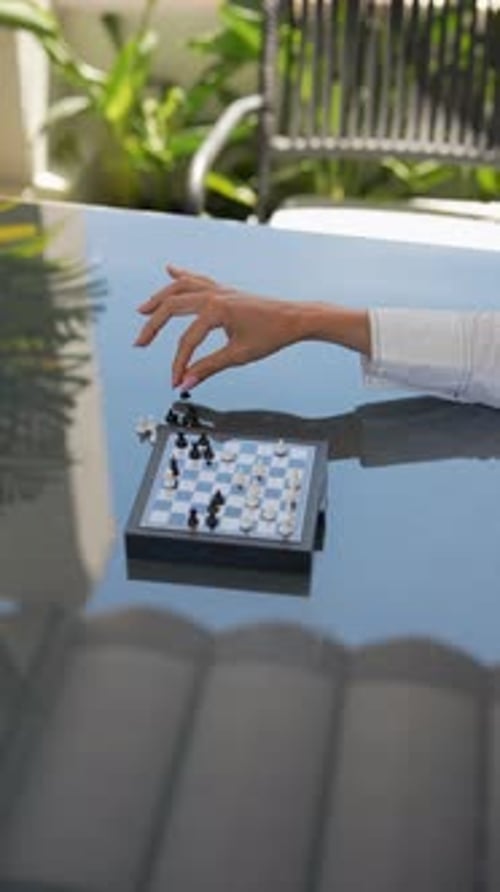 Enjoy an Intense Indoor Chess Game Between Two Players Playing on a Reflective Table