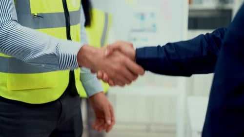 Construction Worker and Businessman Shake Hands Indoors
