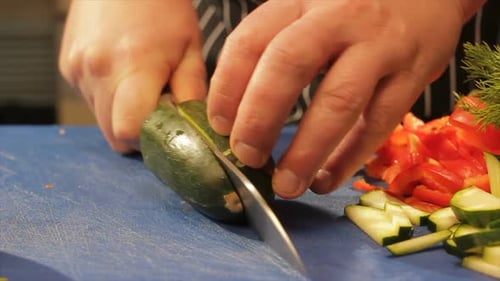 Person Slicing Zucchini on Cutting Board
