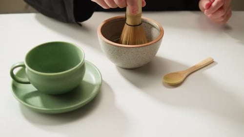 Matcha Green Tea Cooking Process Japanese Powder Green Tea in a Bowl with Bamboo Whisk Macro Close