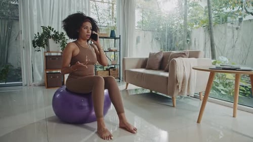 Woman Talking on Phone While Exercising at Home