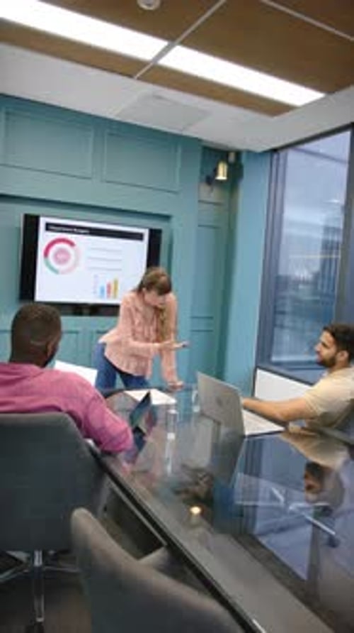 Vertical video: Presenting department budget, woman using laptop discussing with colleagues in offic