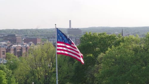 American Flag Waving Over City on Sunny Day