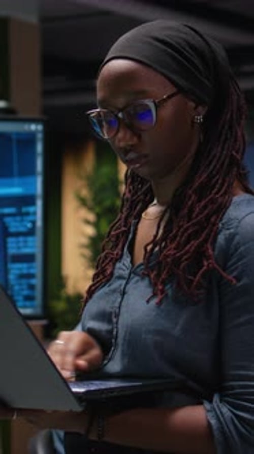 Vertikales Video: Technikerin im Büro nutzt Laptop, um Fehler bei künstlicher Intelligenz zu beheben