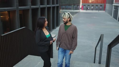 Adult man and woman discussing company business ideas outside the office