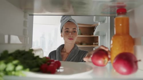 Woman Takes an Apple from Refrigerator