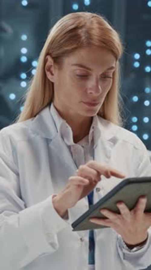 Woman Scientist in Lab Coat Uses Tablet