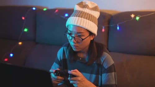 Mädchen auf einer Couch beim Spielen von Online-Videospielen. Professionelle Gamerin, die einen Controller und ein Gamin verwendet
