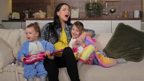 Woman Singing With Two Daughters on Couch