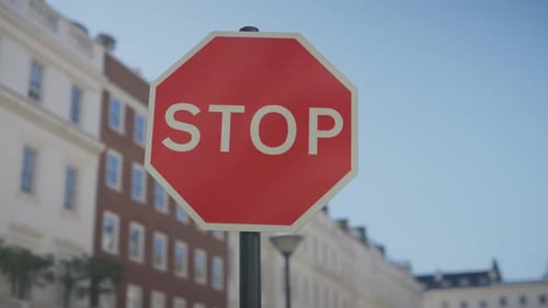 cinematic close-up shot of a classic London stop sign on a quiet upscale street. Shallow depth of
