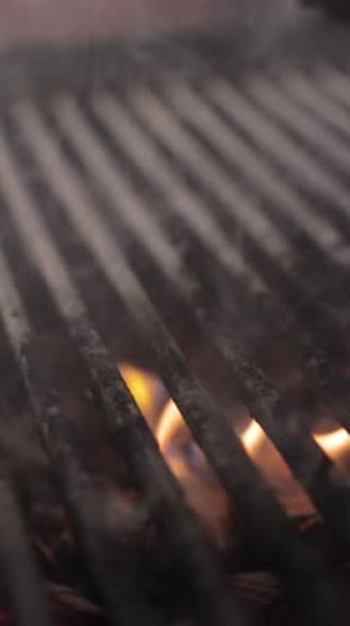 A salmon fillets is turning over on the grill pan with tongs. Fresh red sea fish steak is grilling.