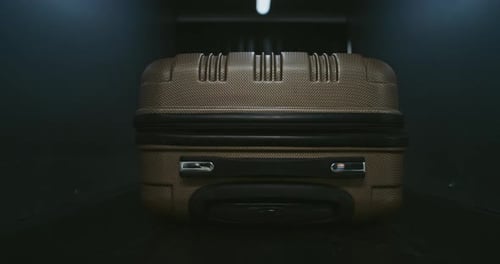Brown Suitcase on Luggage Conveyor Belt with Moody Lighting