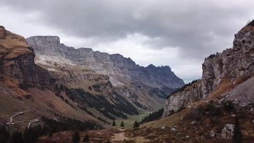 Panoramaaufnahme der Berglandschaft mit kurvenreichen Straßen und bewaldeten Felsen