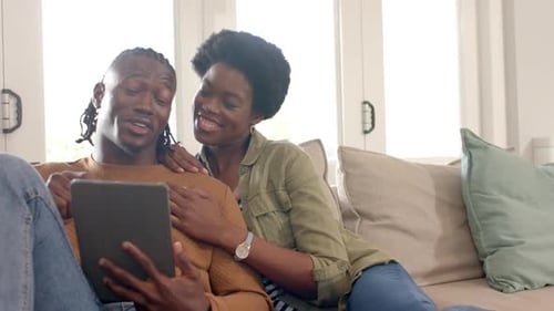 Happy Couple Relaxing on Couch with Tablet