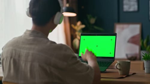Young man video call using green screen laptop