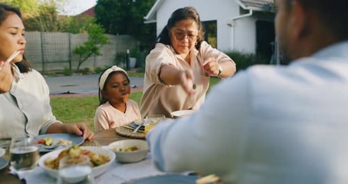 Family Eats Together at Outdoor Suburban Gathering