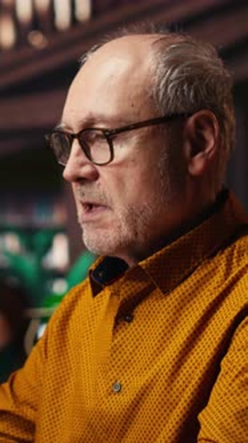 Vertical Video Senior Man at University Wearing Glasses Reading Documents with Focus